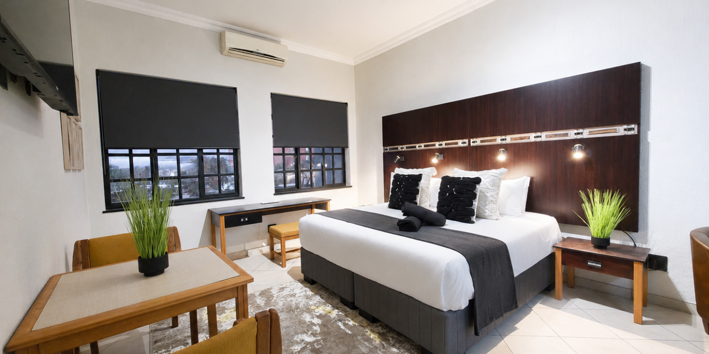 Luxury studio apartment at Promenade Place in Nelspruit with king-size bed, work desk and dining area.